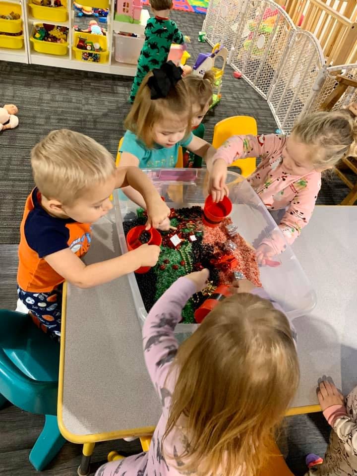 Children playing with sensory bin at a table