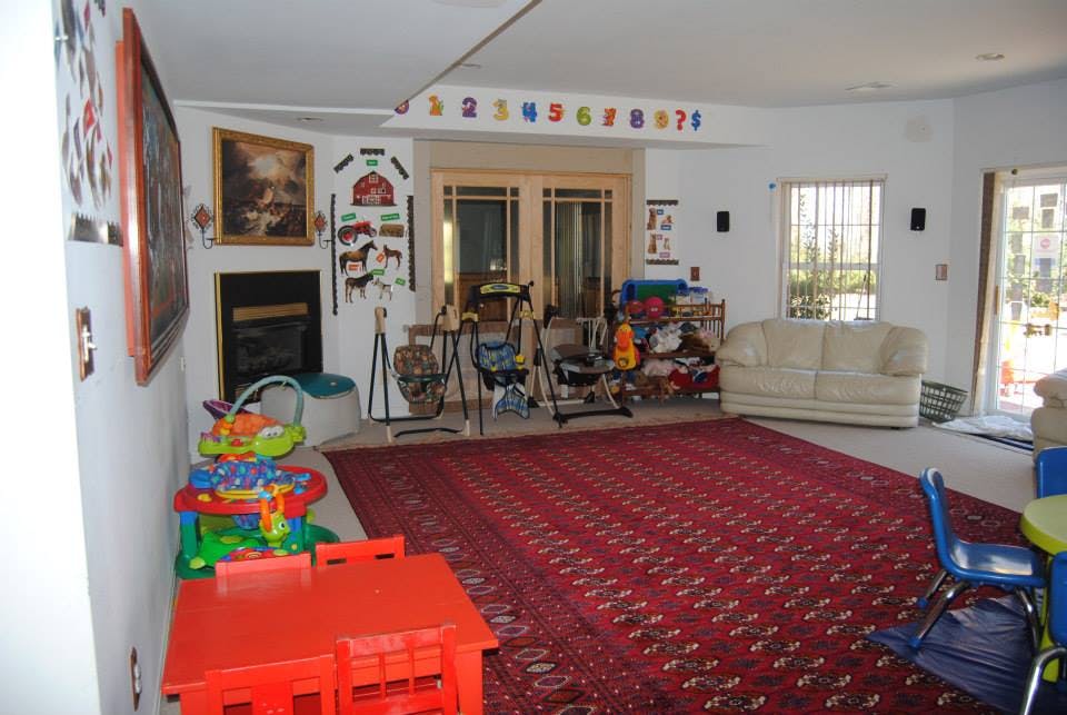 Playroom with red rug, small red table, and various toys
