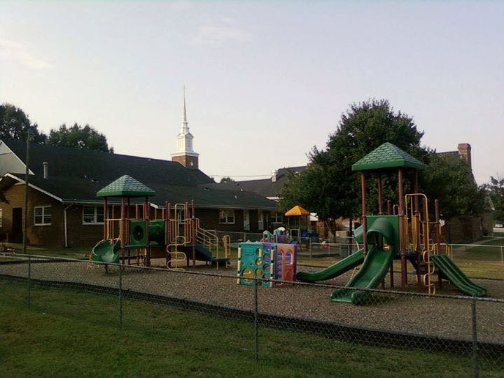 Playground with slides and climbing structures in front of a building