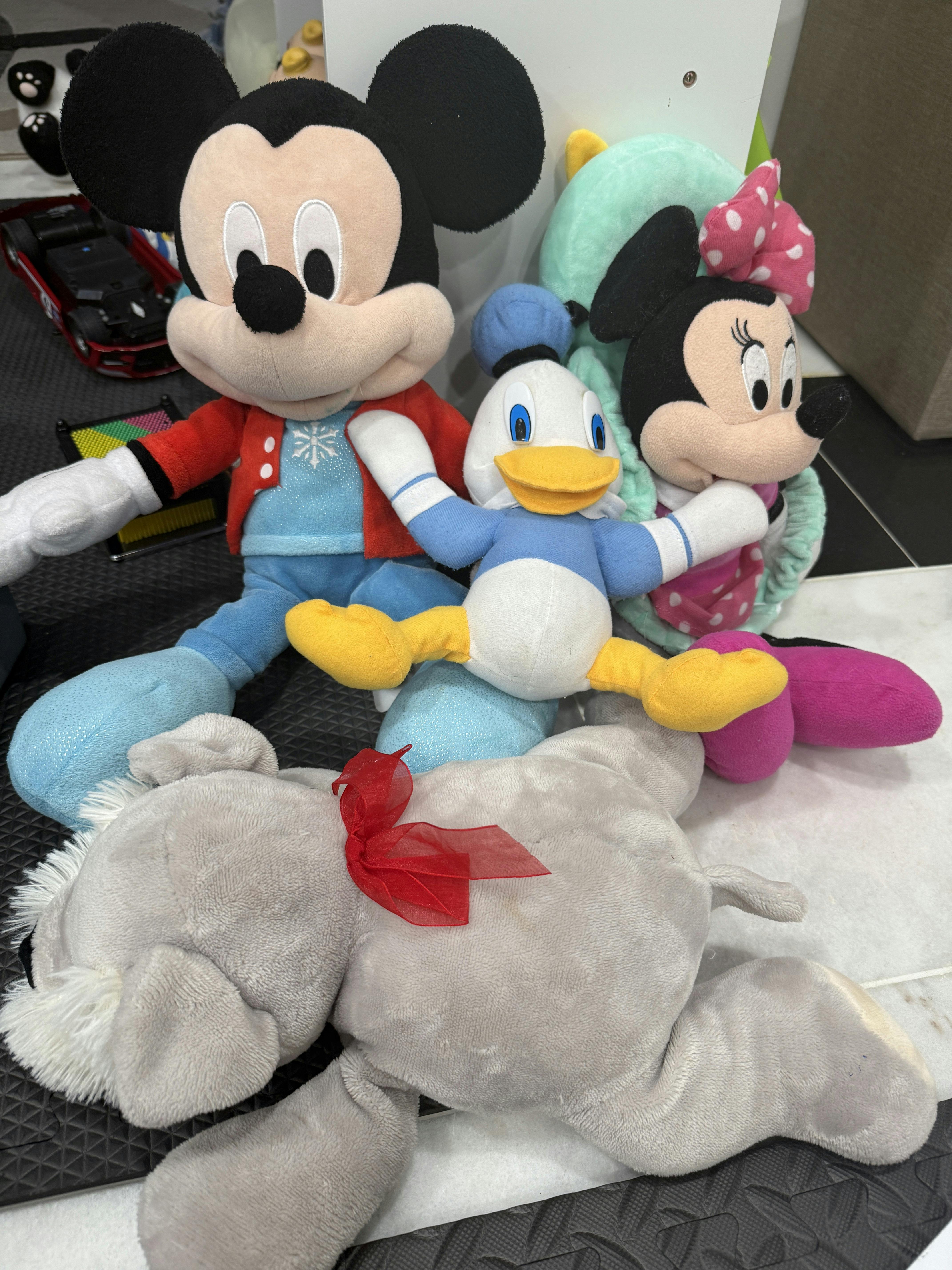Collection of plush toy characters including Mickey, Minnie, and Donald