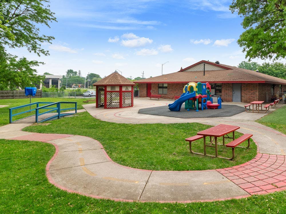 Outdoor playground with colorful equipment, a gazebo, and picnic tables