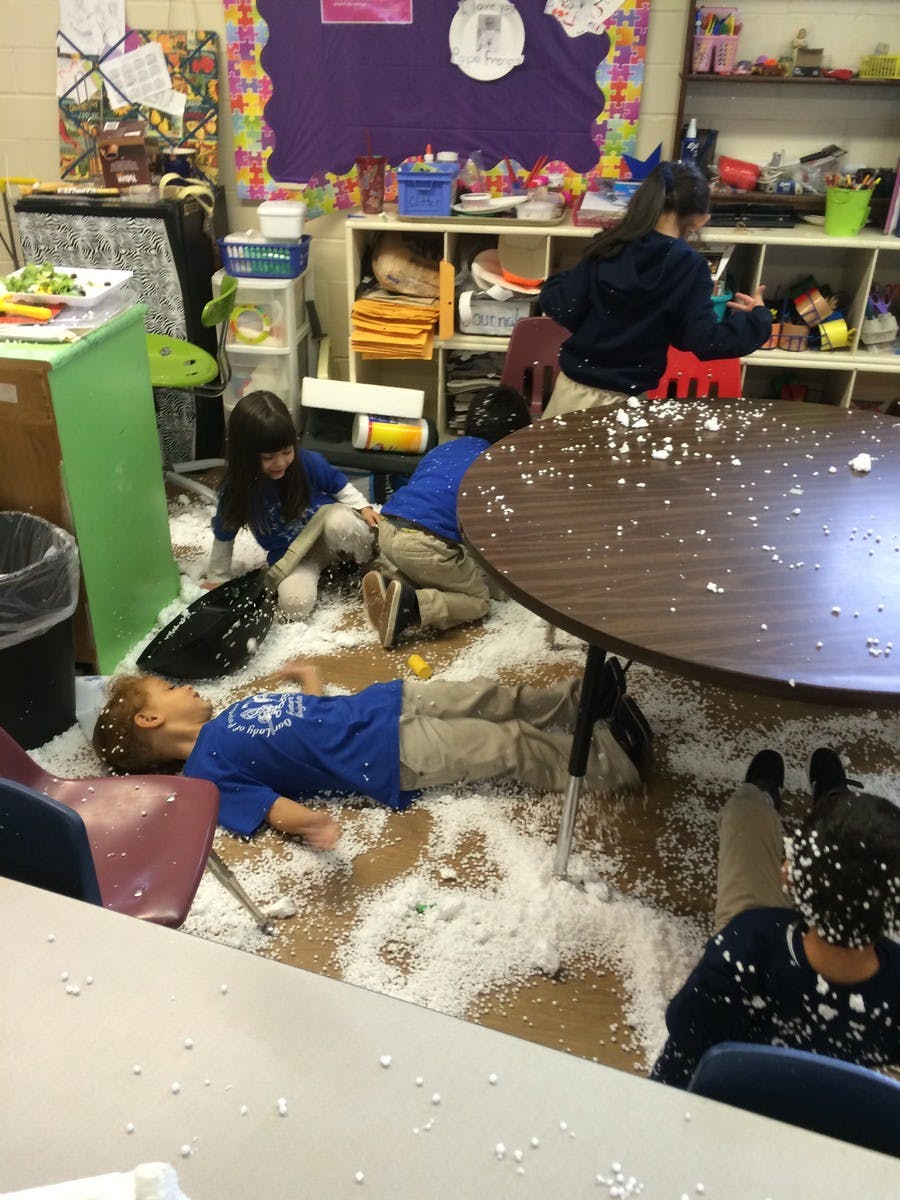 Children playing in a classroom with white foam on the floor