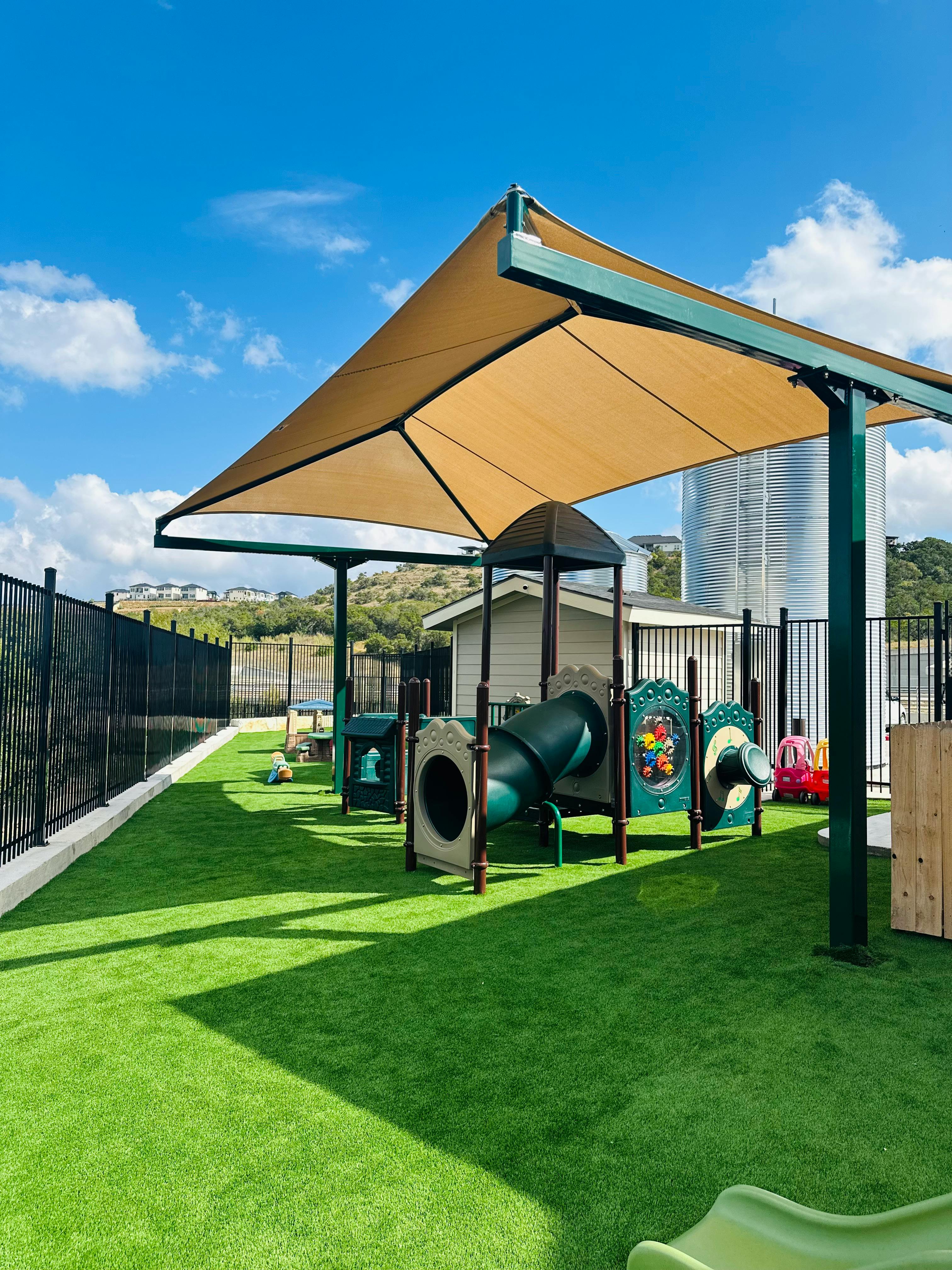 Playground with artificial turf and shade structure