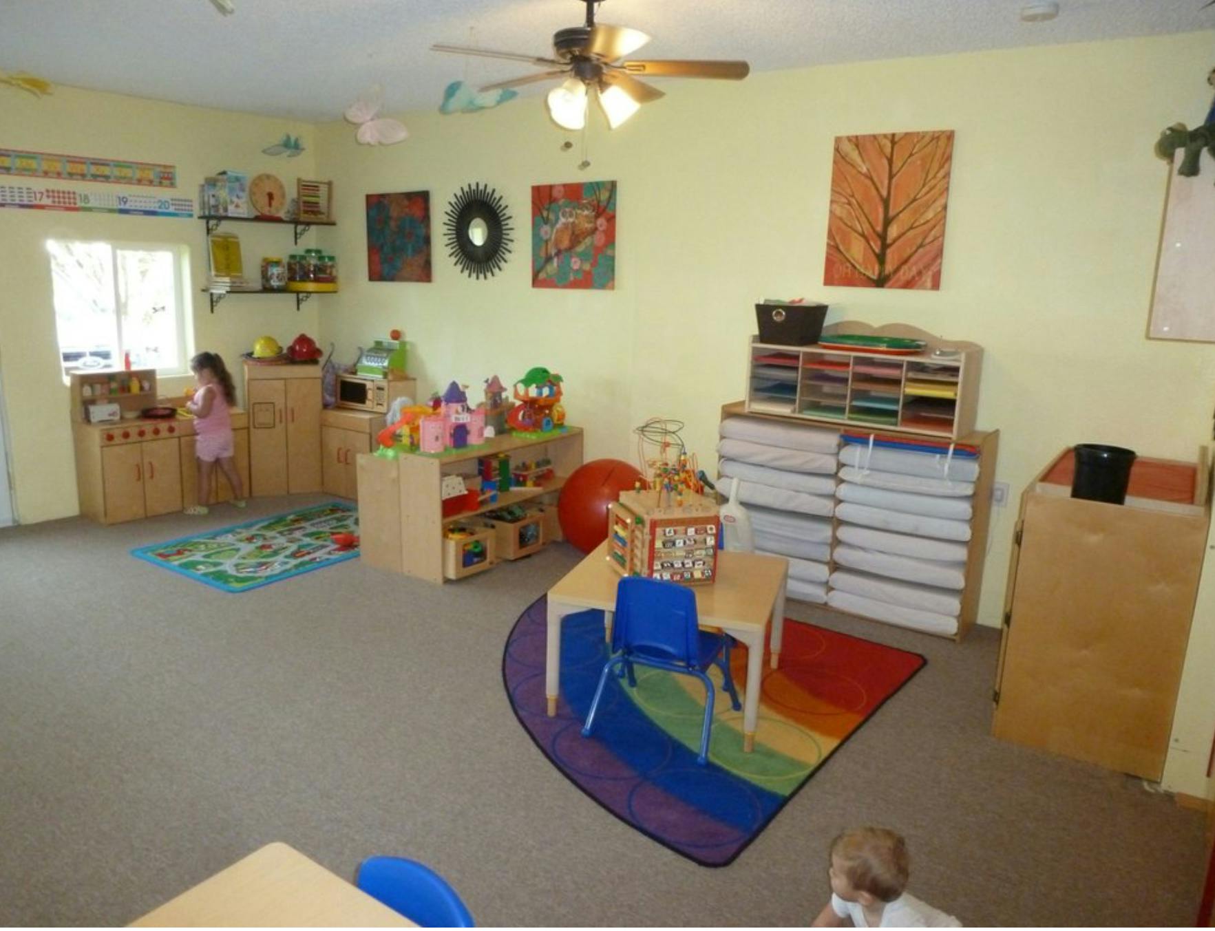 Child playing in a classroom with toys and furniture