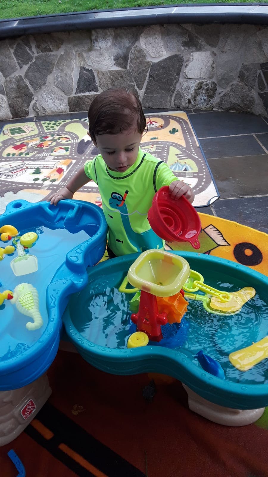 Child playing with a water table and toys