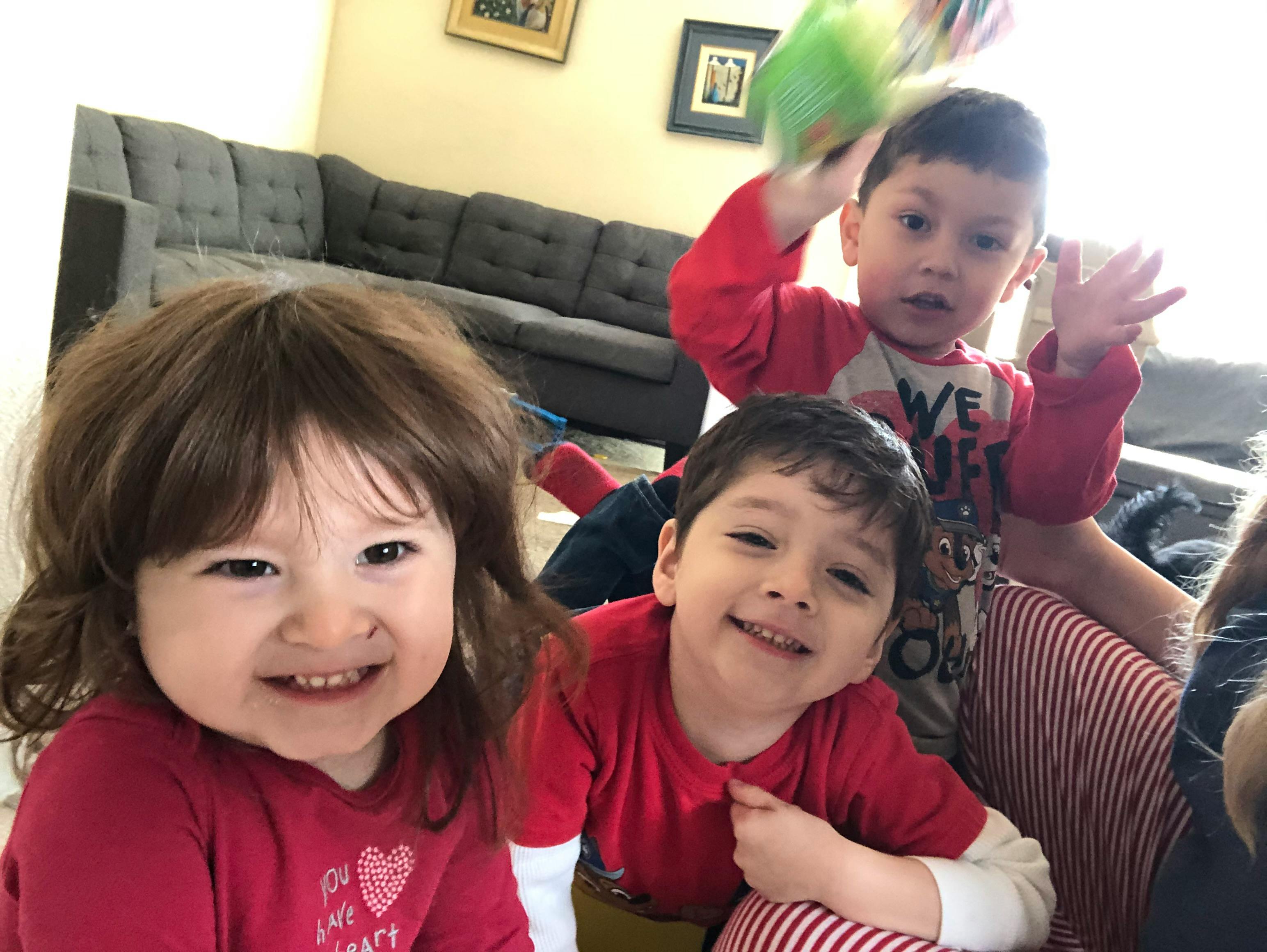 Three young children smiling and looking at the camera