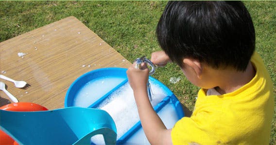 Child playing with bubbles outdoors