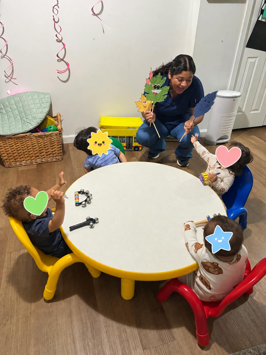 Adult using paper puppets to entertain four children seated around a table