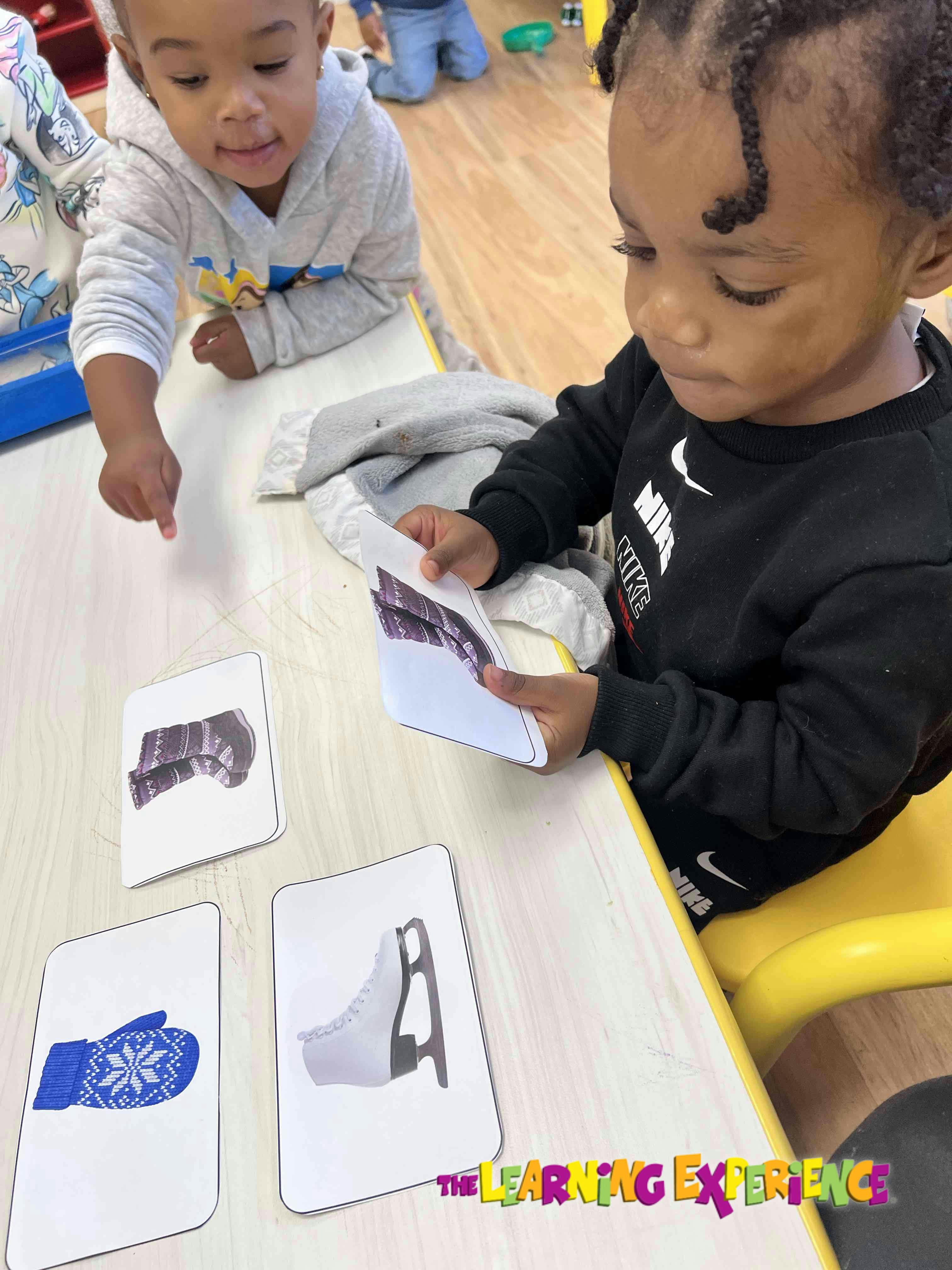 Two children playing with picture cards on a table
