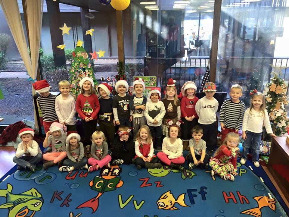 Group of children wearing Santa hats in a classroom