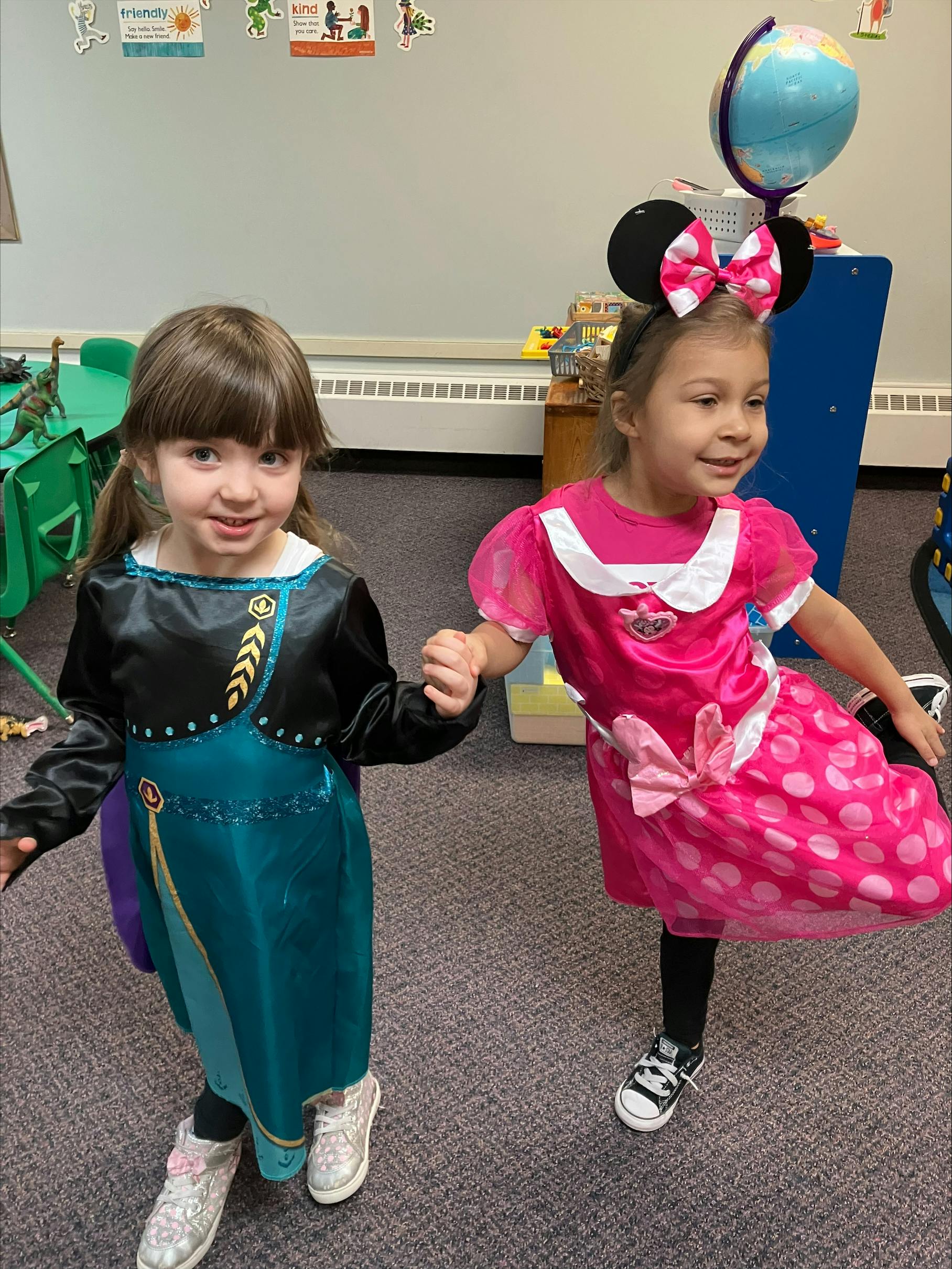 Two children in costumes holding hands