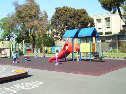Children playing on a playground with slides and climbing structures