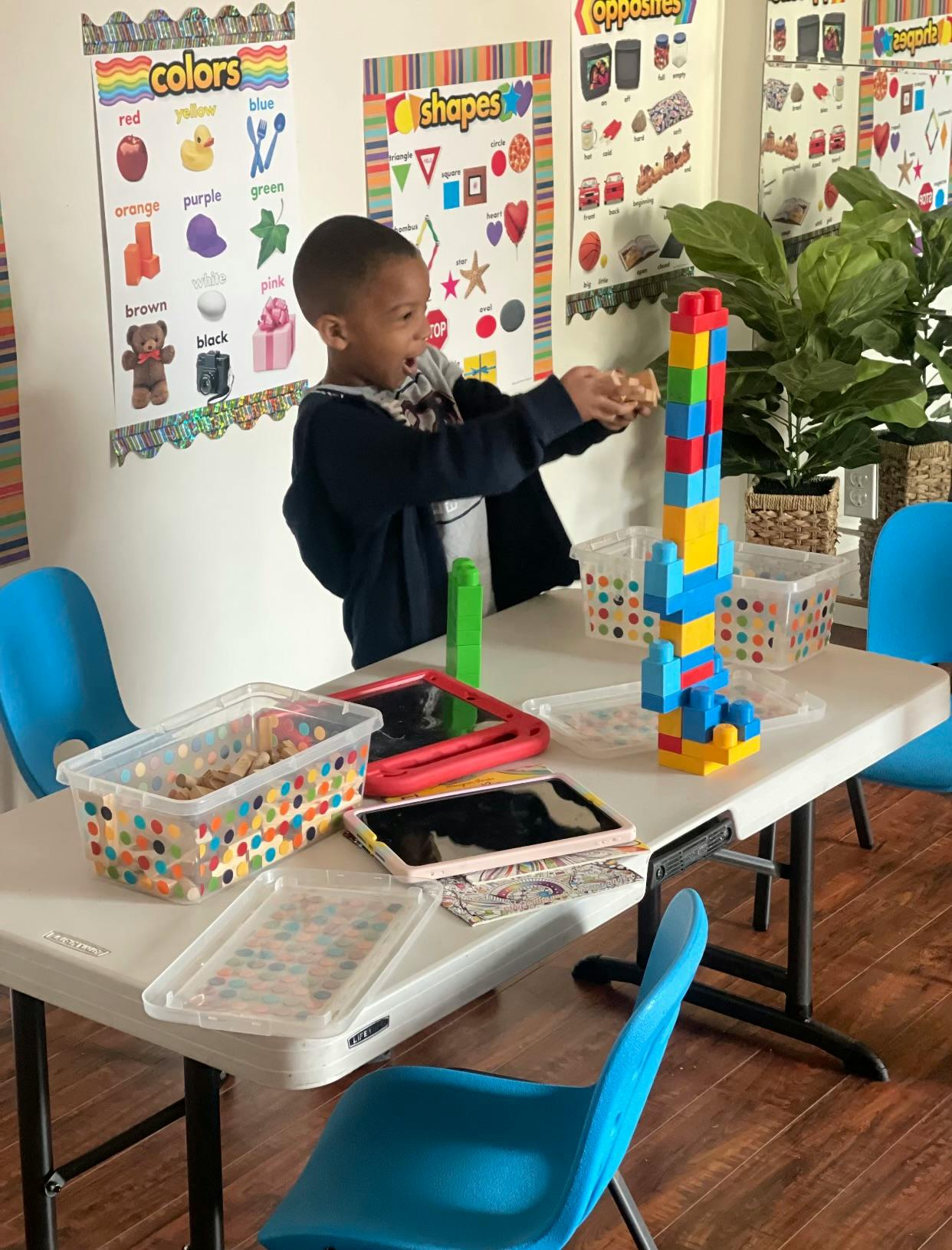 Child playing with colorful building blocks at a table