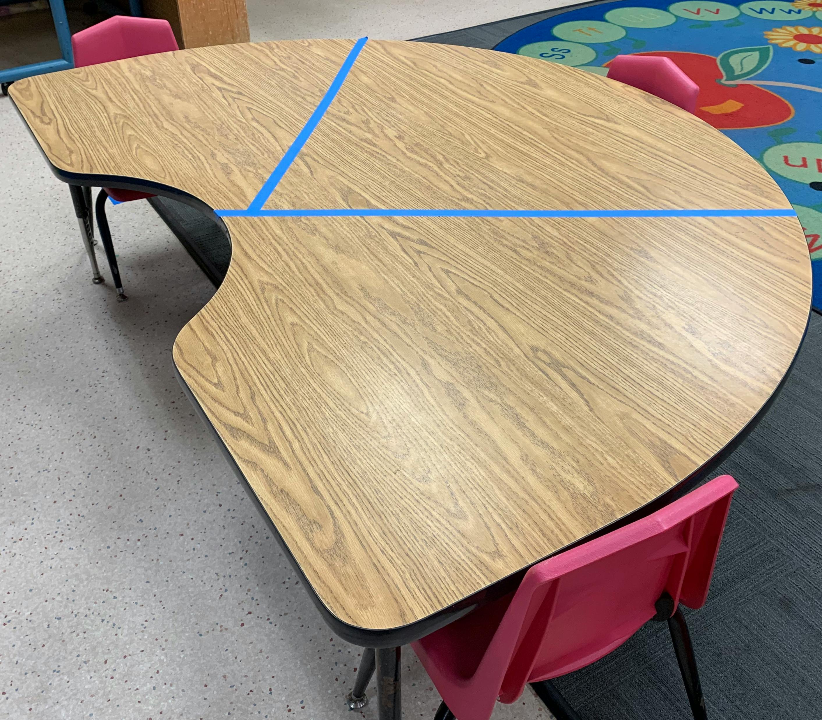 Classroom table with blue tape on the surface