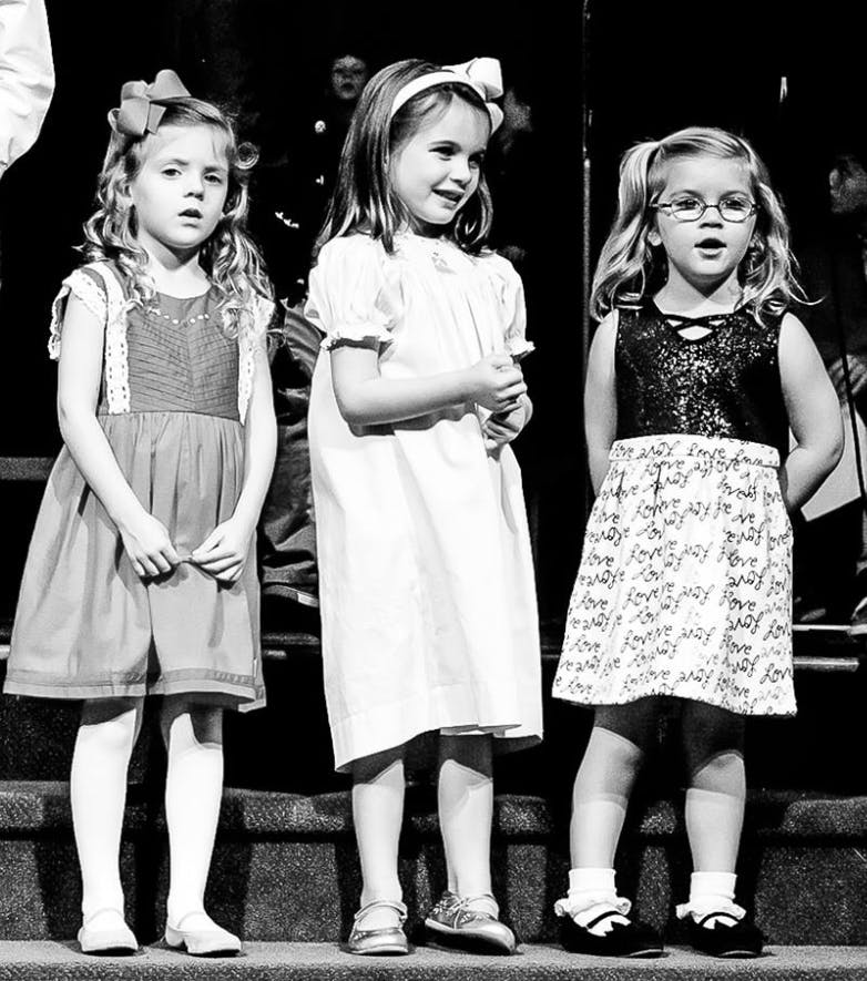 Three children standing in a row
