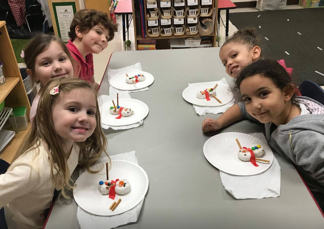 Children at a table with snowman crafts
