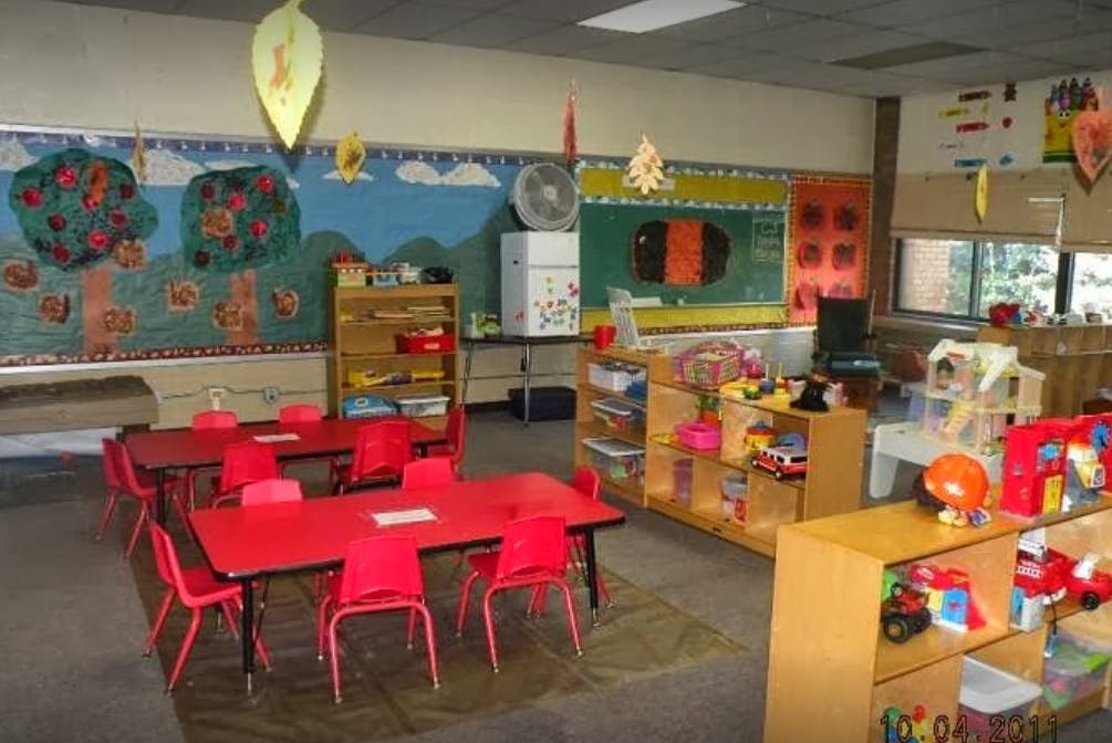 Empty classroom with red tables and chairs
