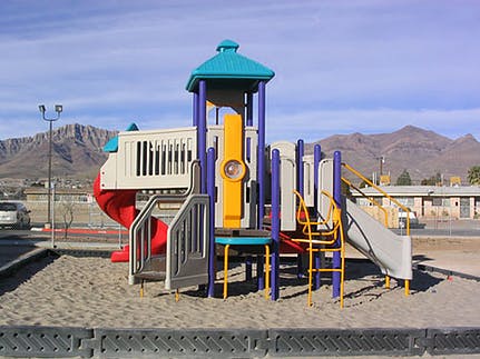 Playground structure with slides and climbing elements on sand