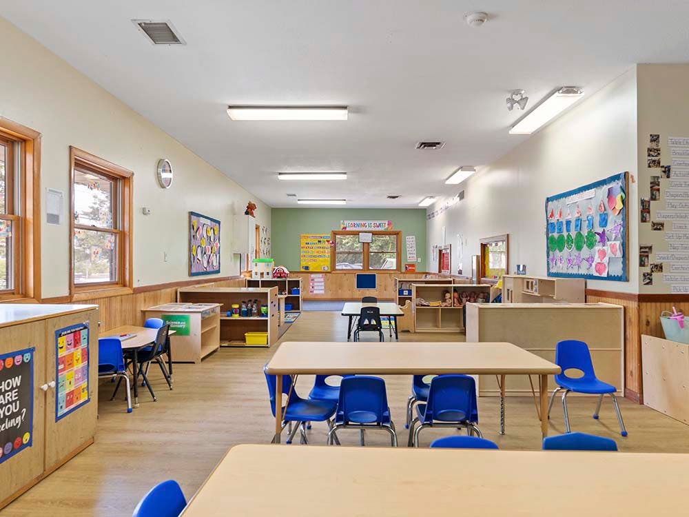 Empty classroom with small tables and blue chairs