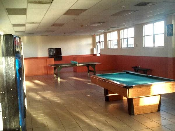 Pool table and ping pong table in a room with windows