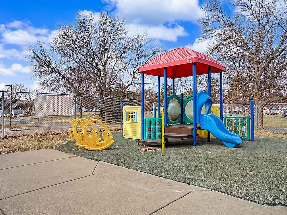 Colorful playground structure with a red roof and blue slide