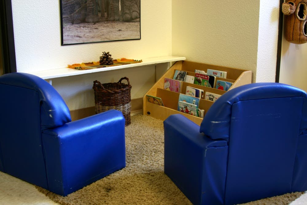 Two blue chairs facing each other in a room with a bookshelf
