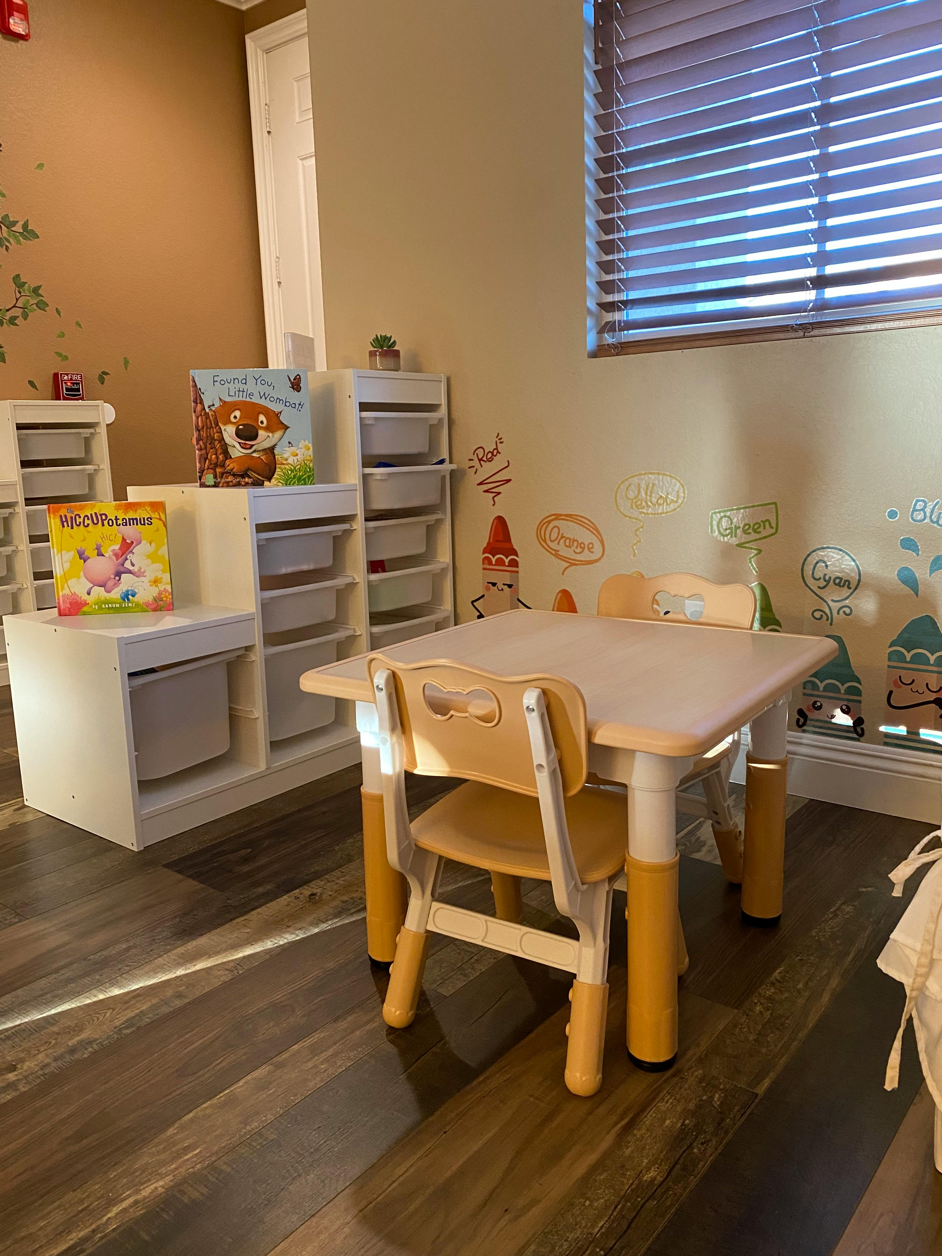 Children's table and chairs in a room with storage units and books