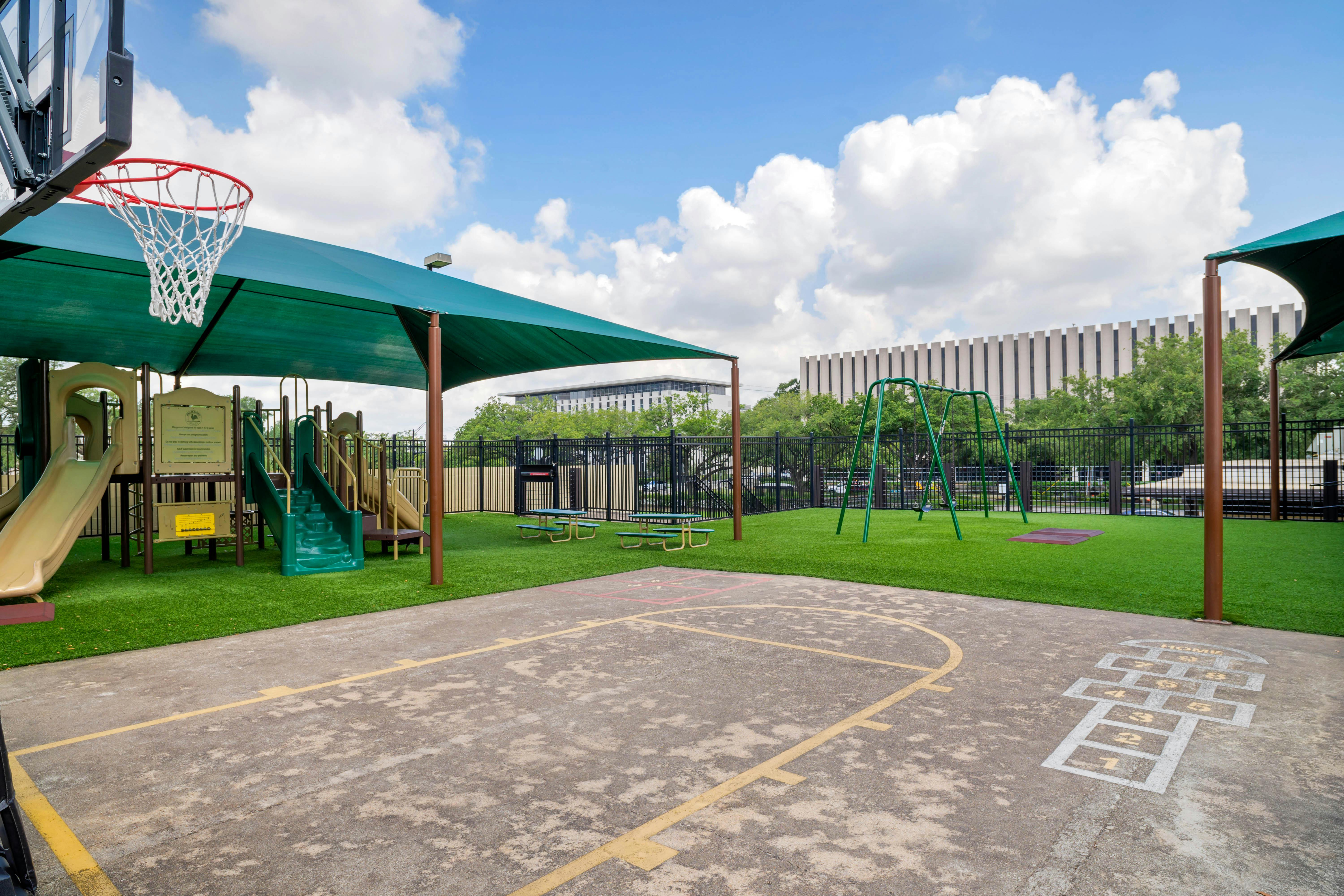 Playground with slides, swings, picnic tables, hopscotch, and basketball hoop