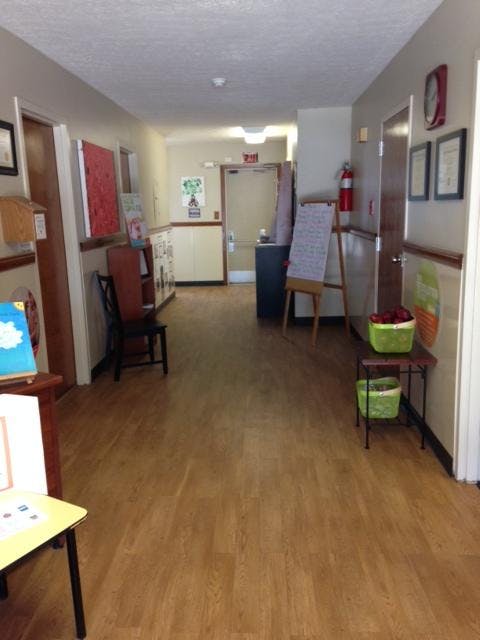 Hallway with wood floors, doors, and a whiteboard