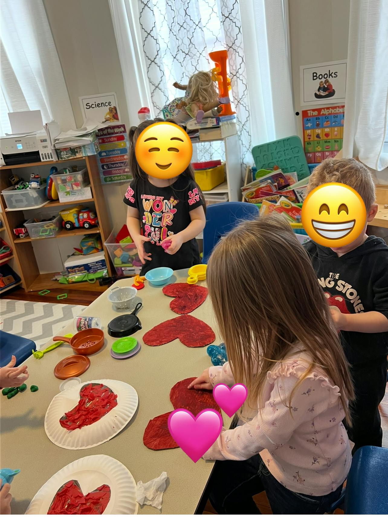 Children at a table with heart-shaped crafts and cooking-themed crafts