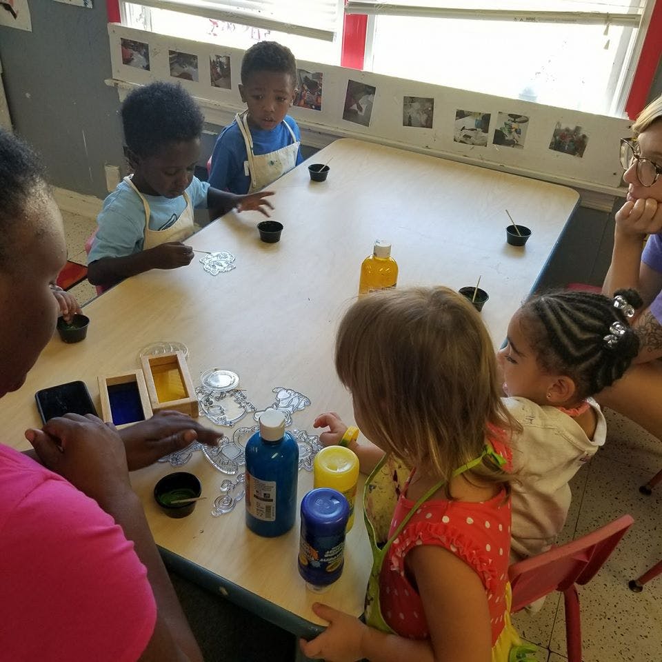 Adults and children at a table with craft supplies