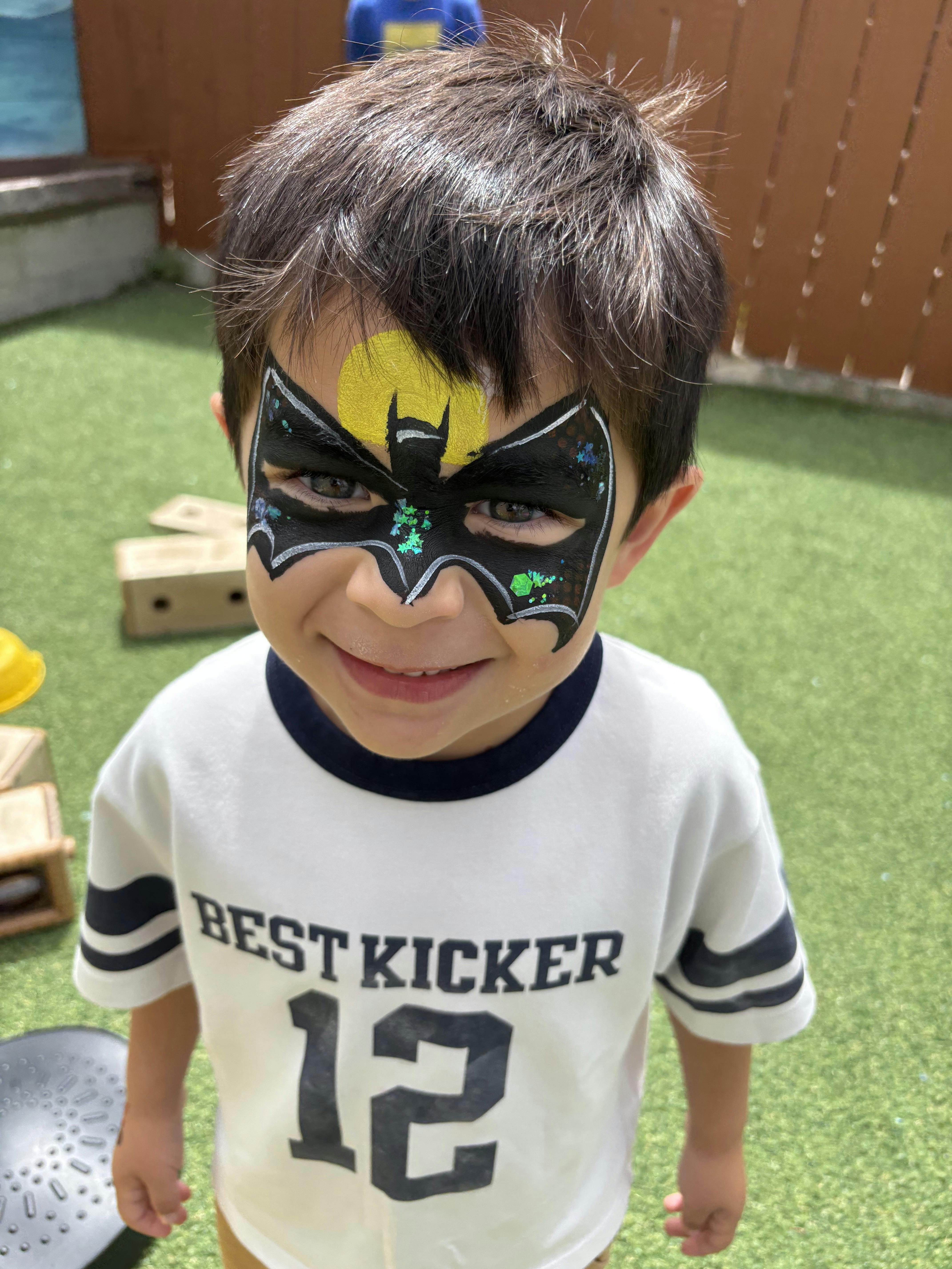 Child wearing bat-themed face paint