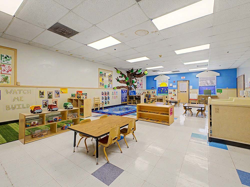 Empty colorful children's classroom with small tables and chairs