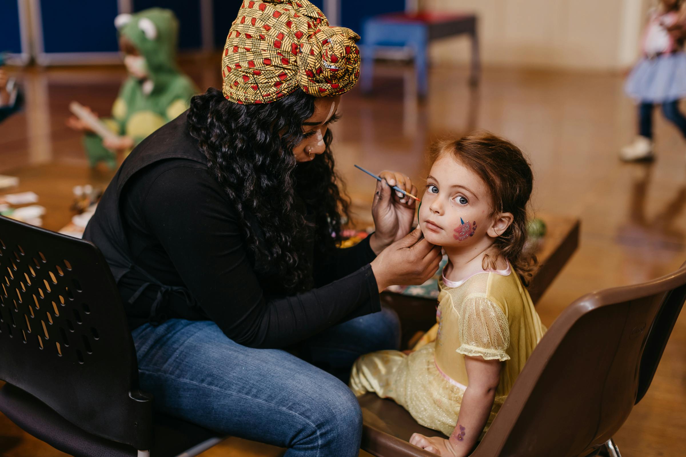 Person face painting a child