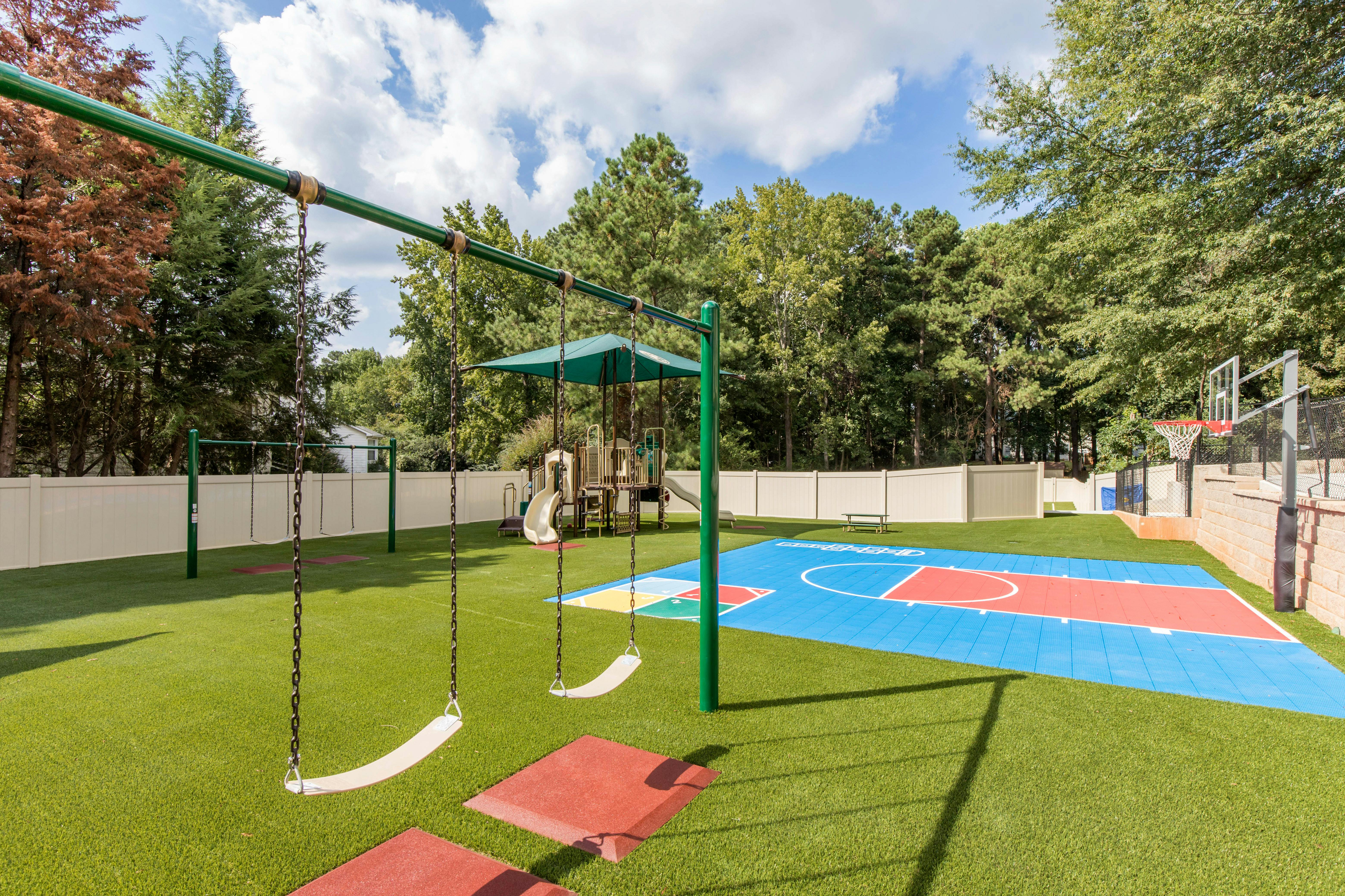 Playground with swings, play structure, and basketball court