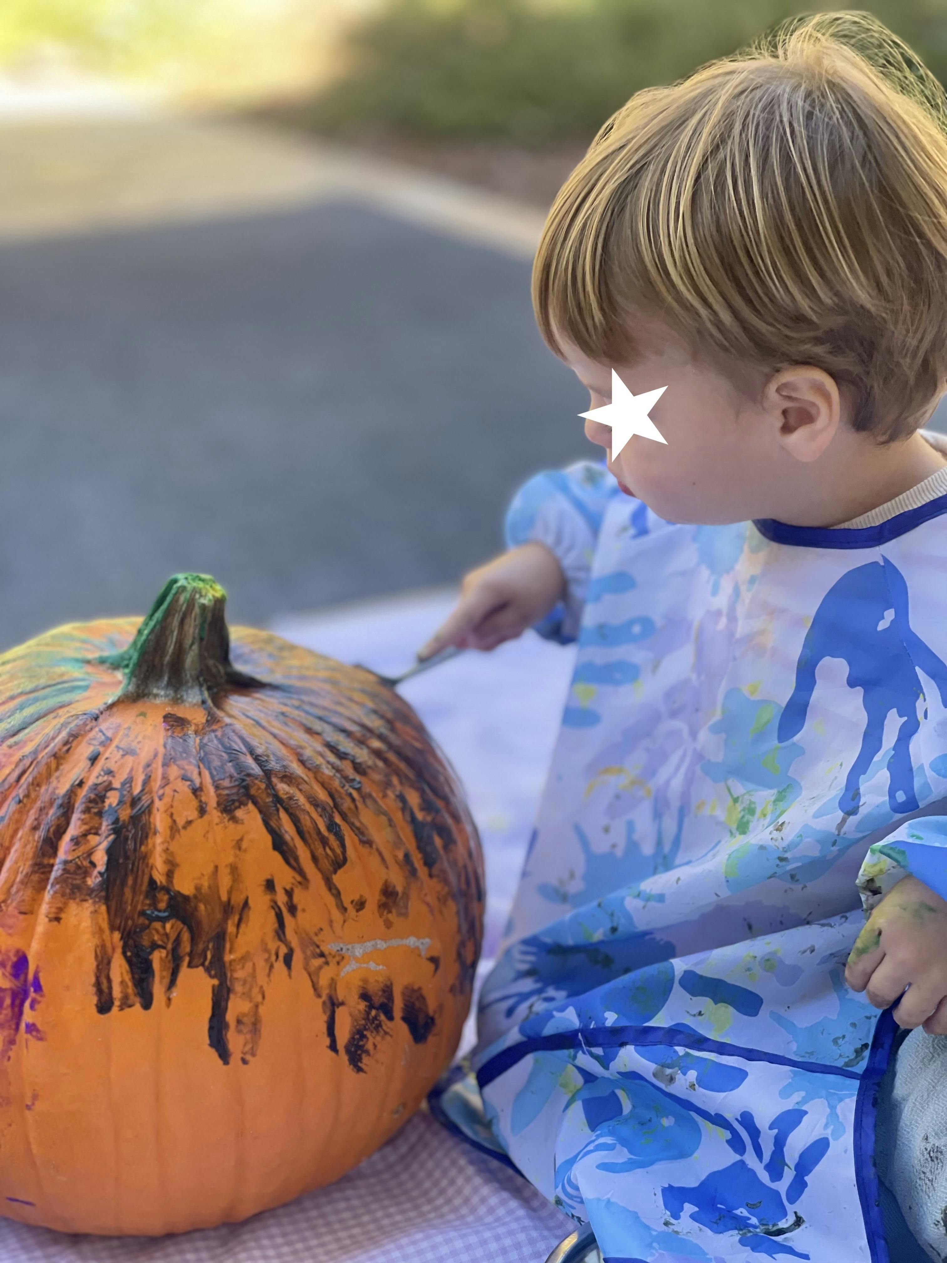 Child painting a pumpkin