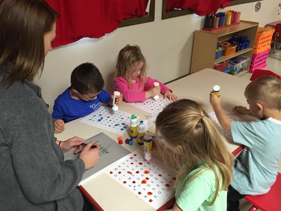 Adult and children doing an art activity at a table