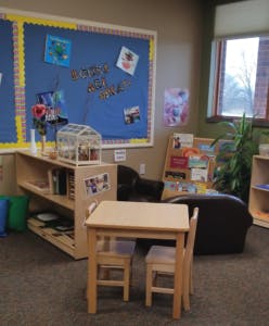 Small table and chairs in a classroom with a bulletin board