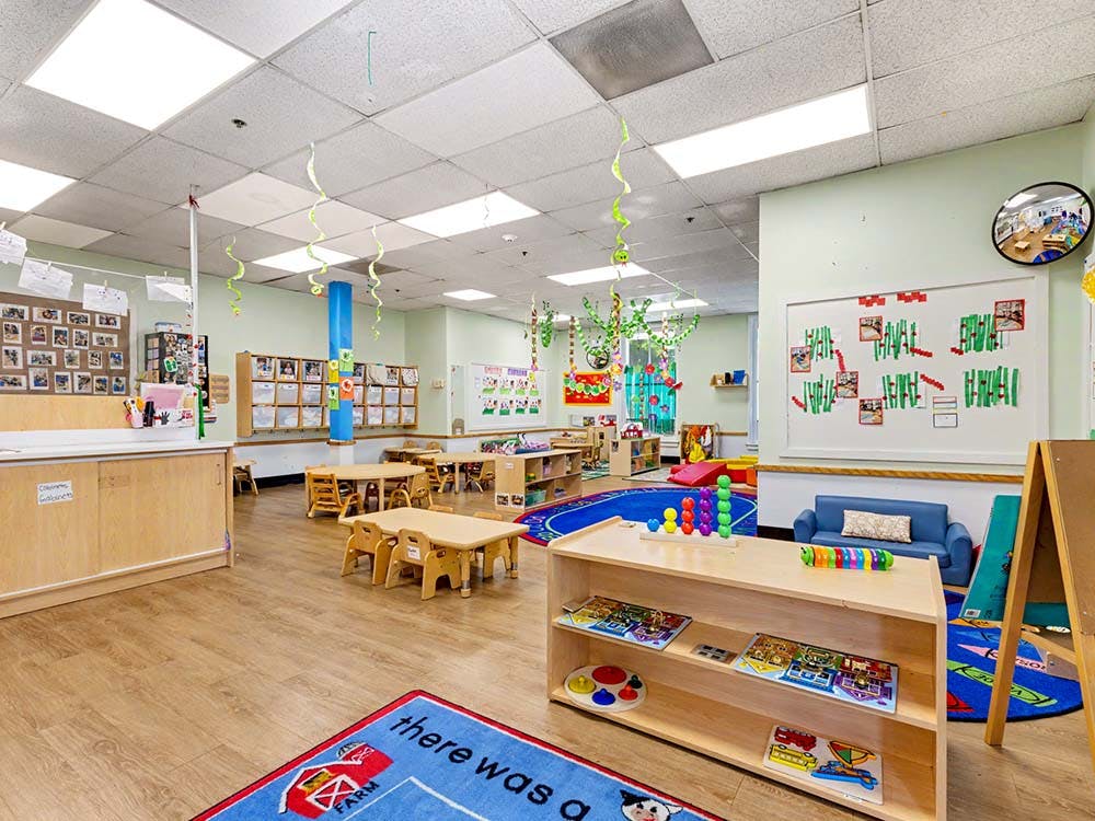 Classroom with small tables and chairs, toys, and decorations
