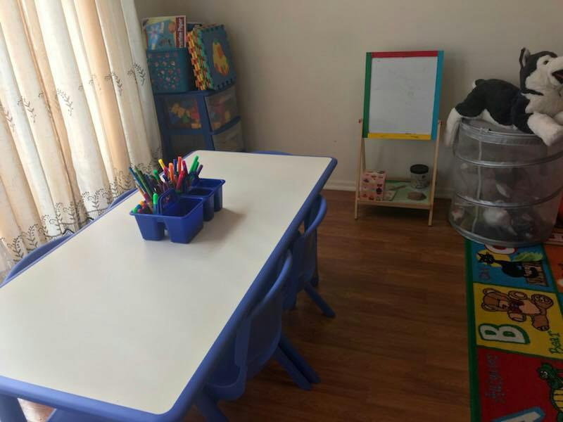 Children's table and chairs with art supplies in a room