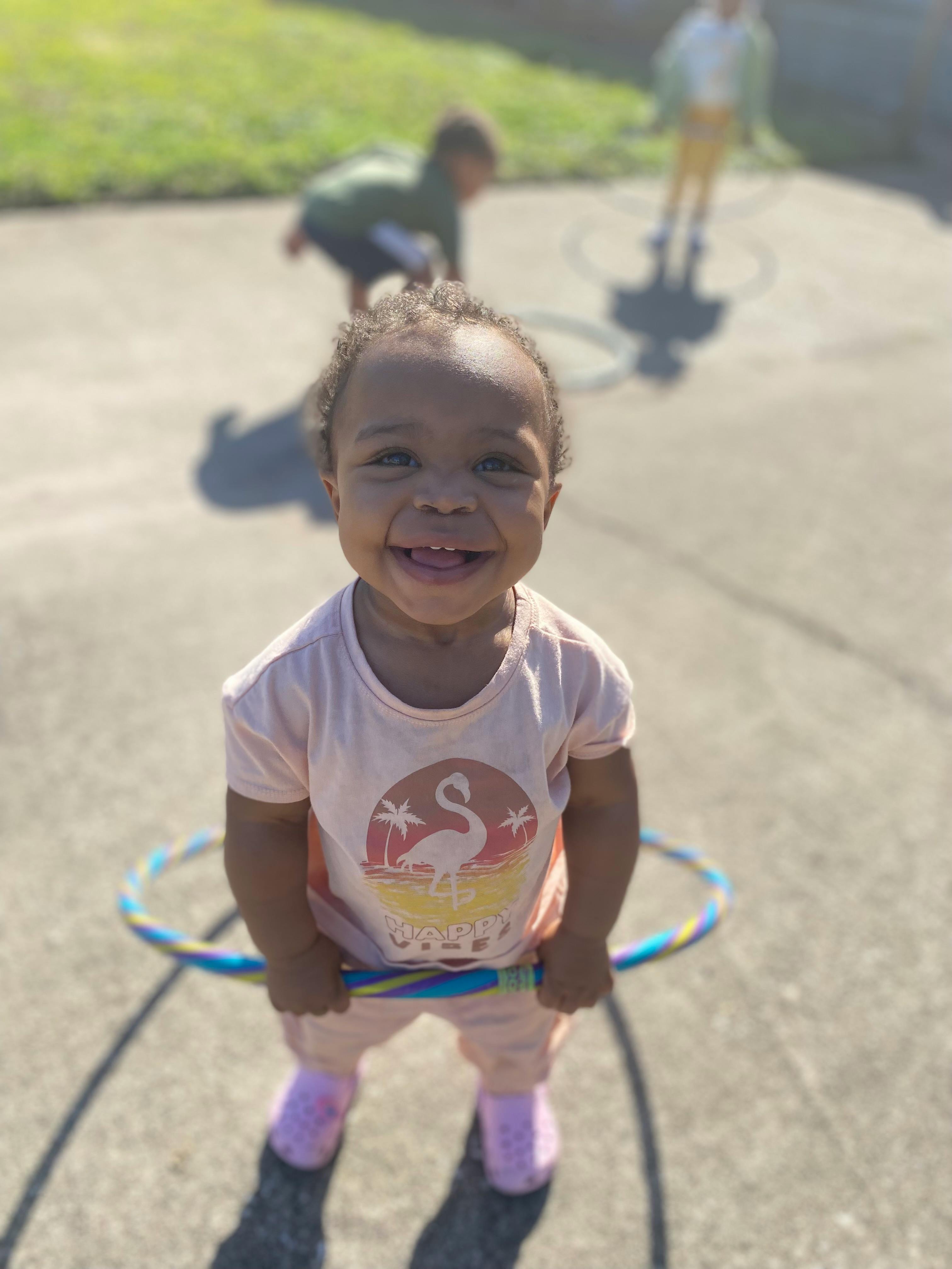 Child holding a hula hoop outdoors