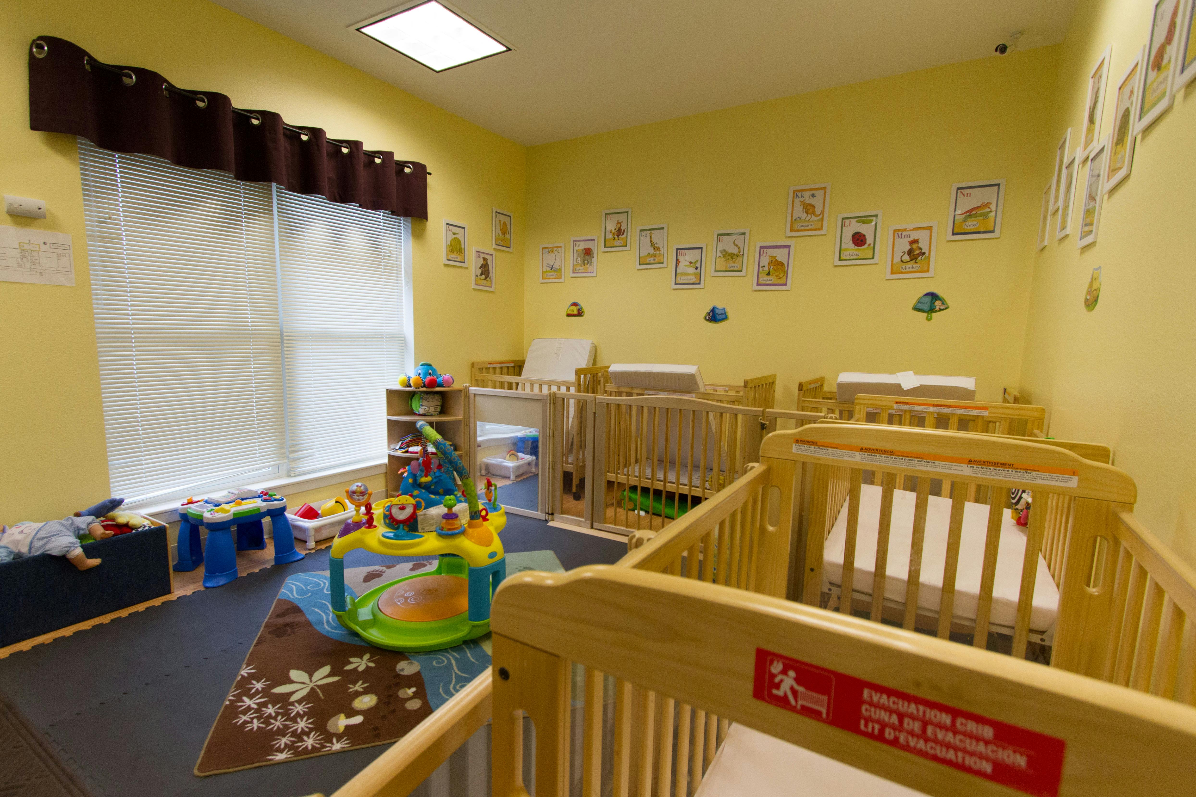 Nursery room with multiple cribs and changing stations