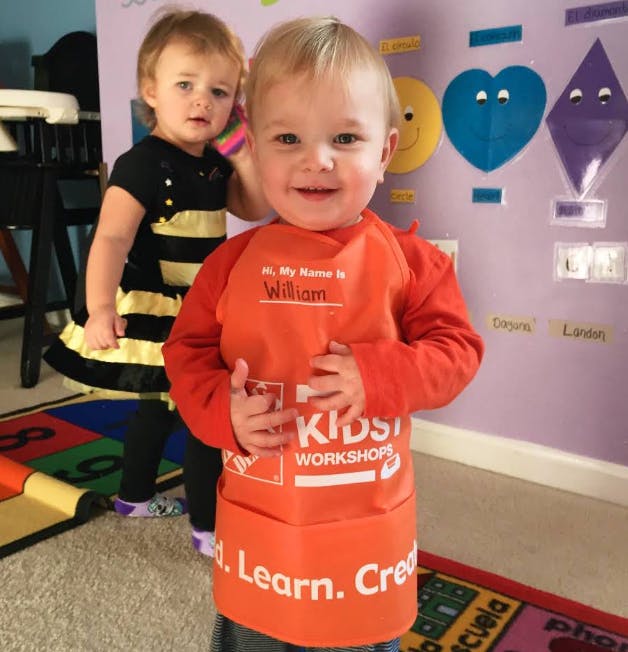 Child in orange apron with "My Name is William" and another child behind