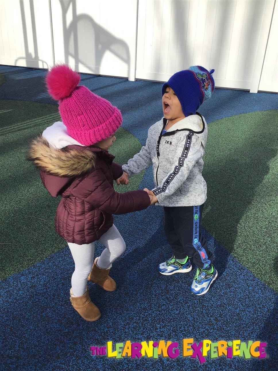 Two children holding hands on a playground