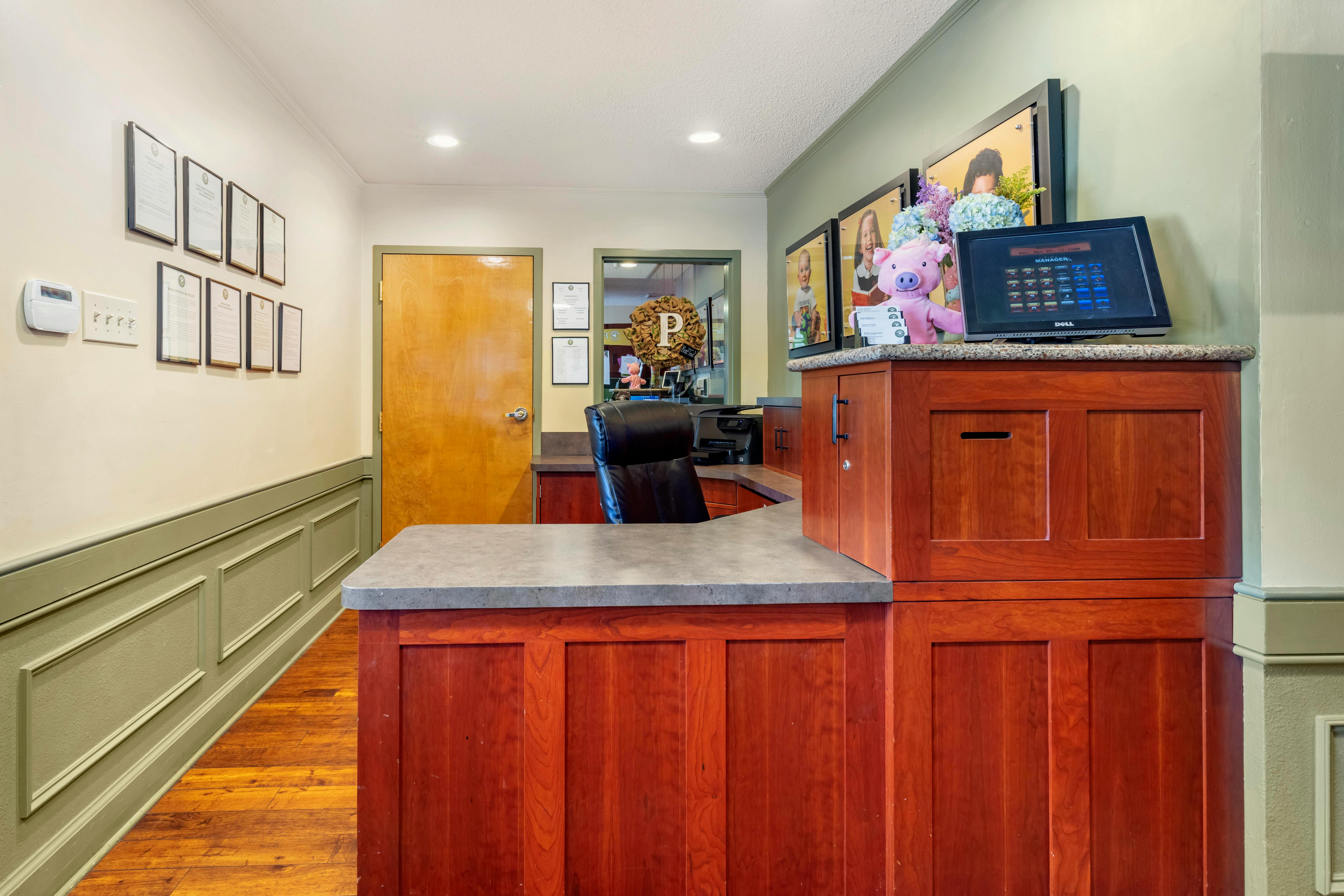 Reception desk with framed documents on wall