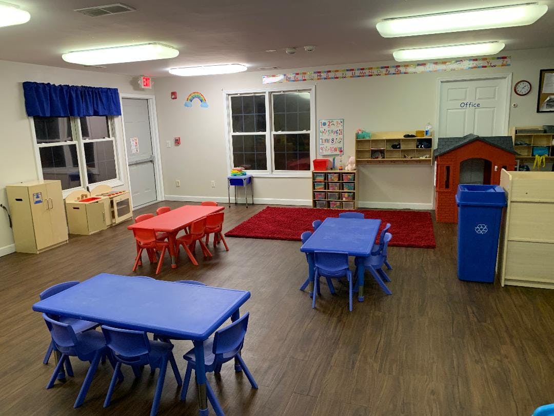 Empty classroom with small blue and red tables and chairs