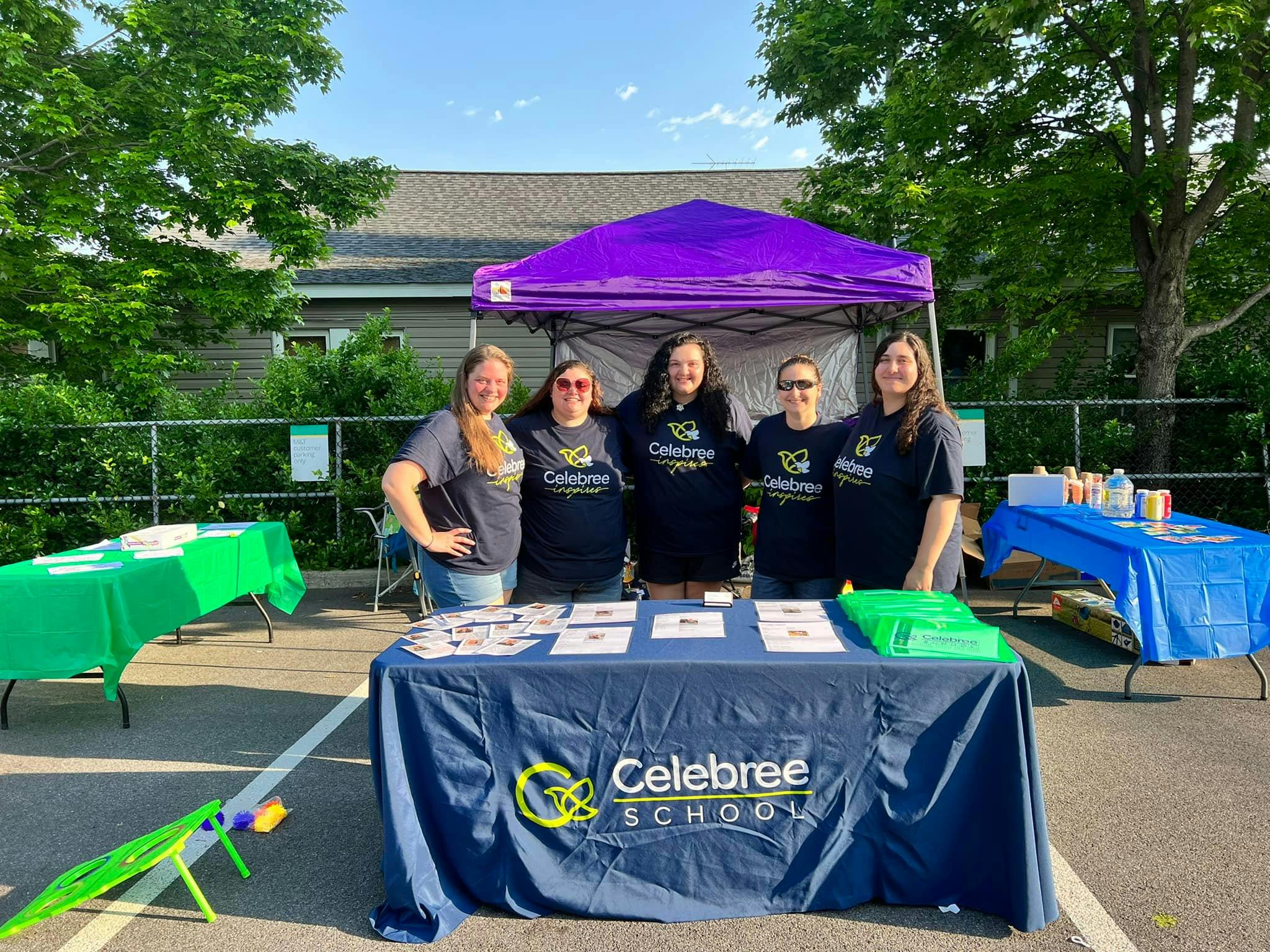 Five people standing behind a table with a Celebree School banner