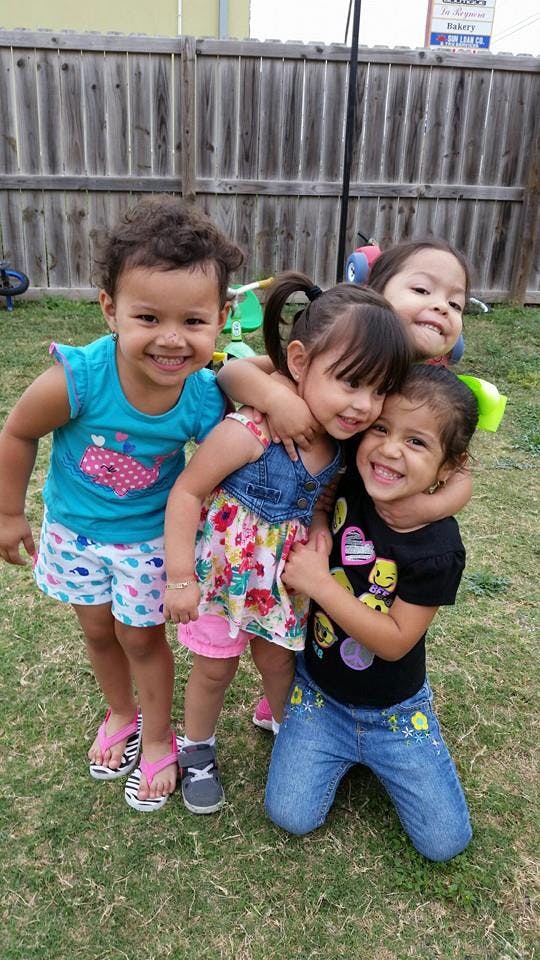 Four children posing together outdoors