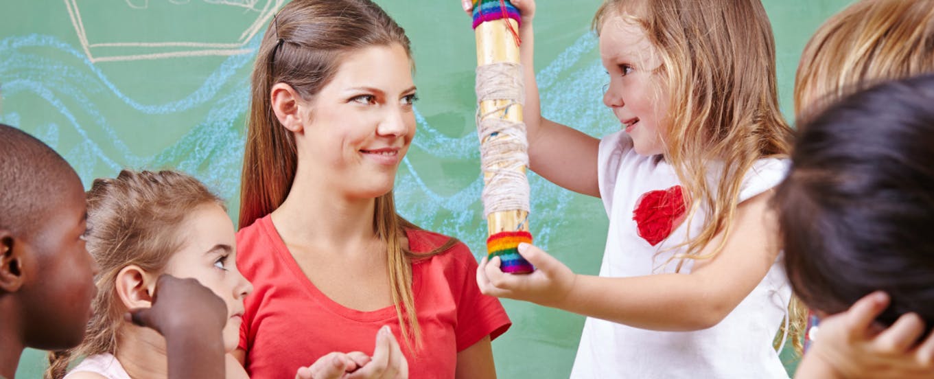 Person and child holding a colorful rainstick