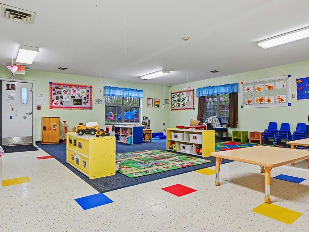 Classroom with small tables, chairs, and play areas